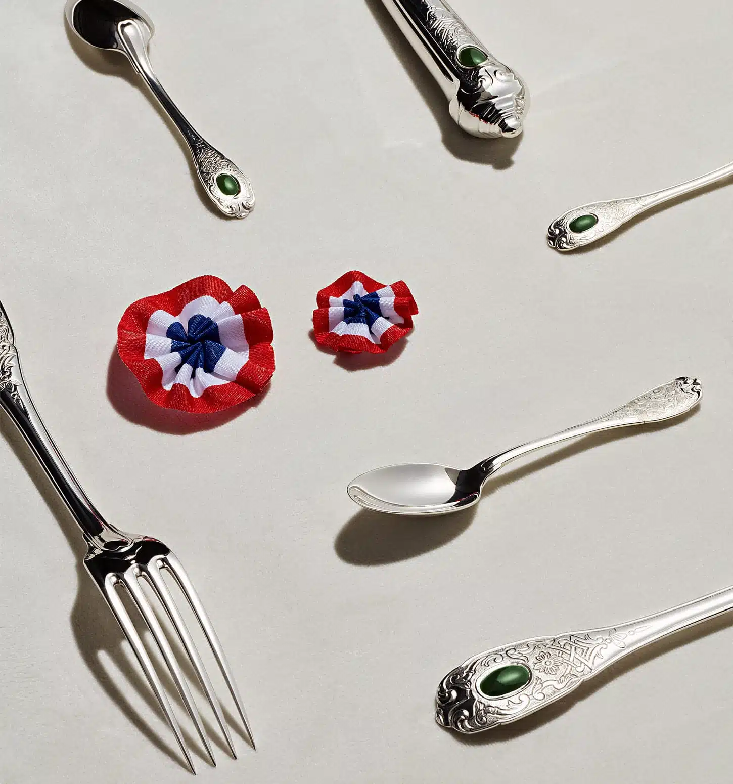 Couverts de table de la collection Elysée en argent massif et jade photographiés sur un fond blanc à côté de plusieurs en symbole de la république française