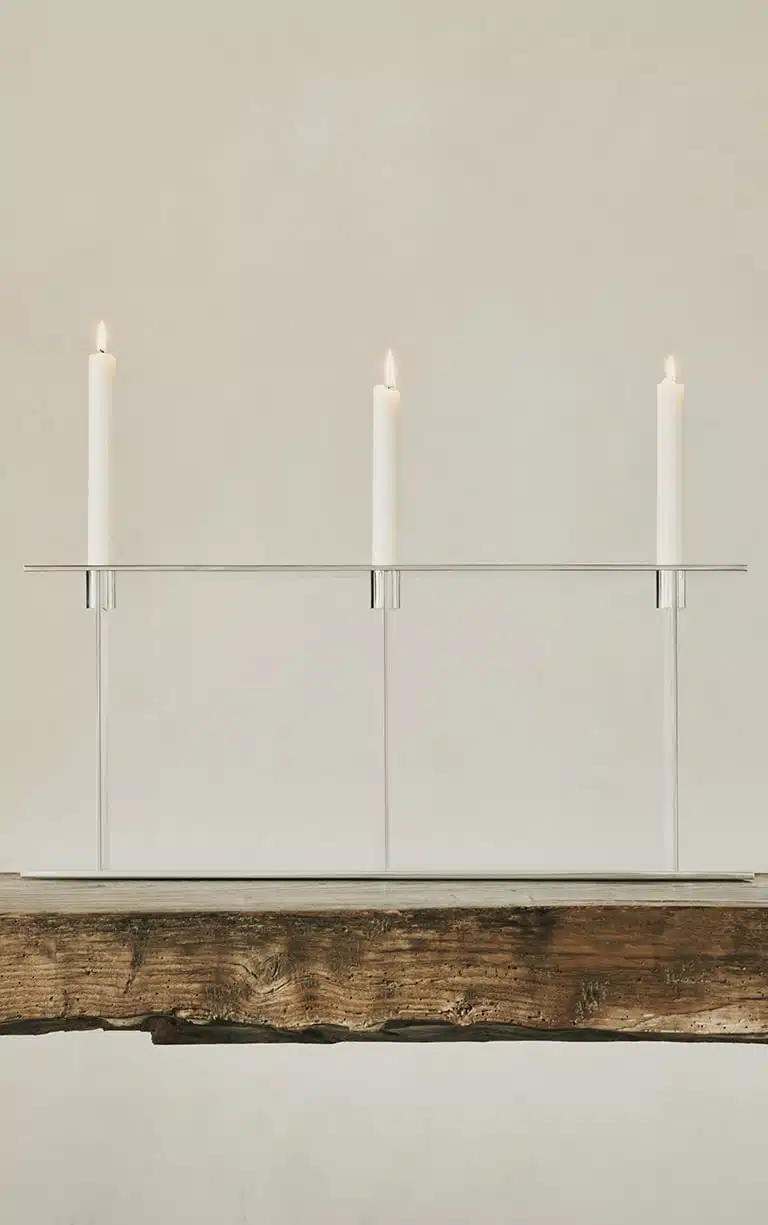Candélabre trois lumières de la collection Pilotis, posé sur une table en bois.