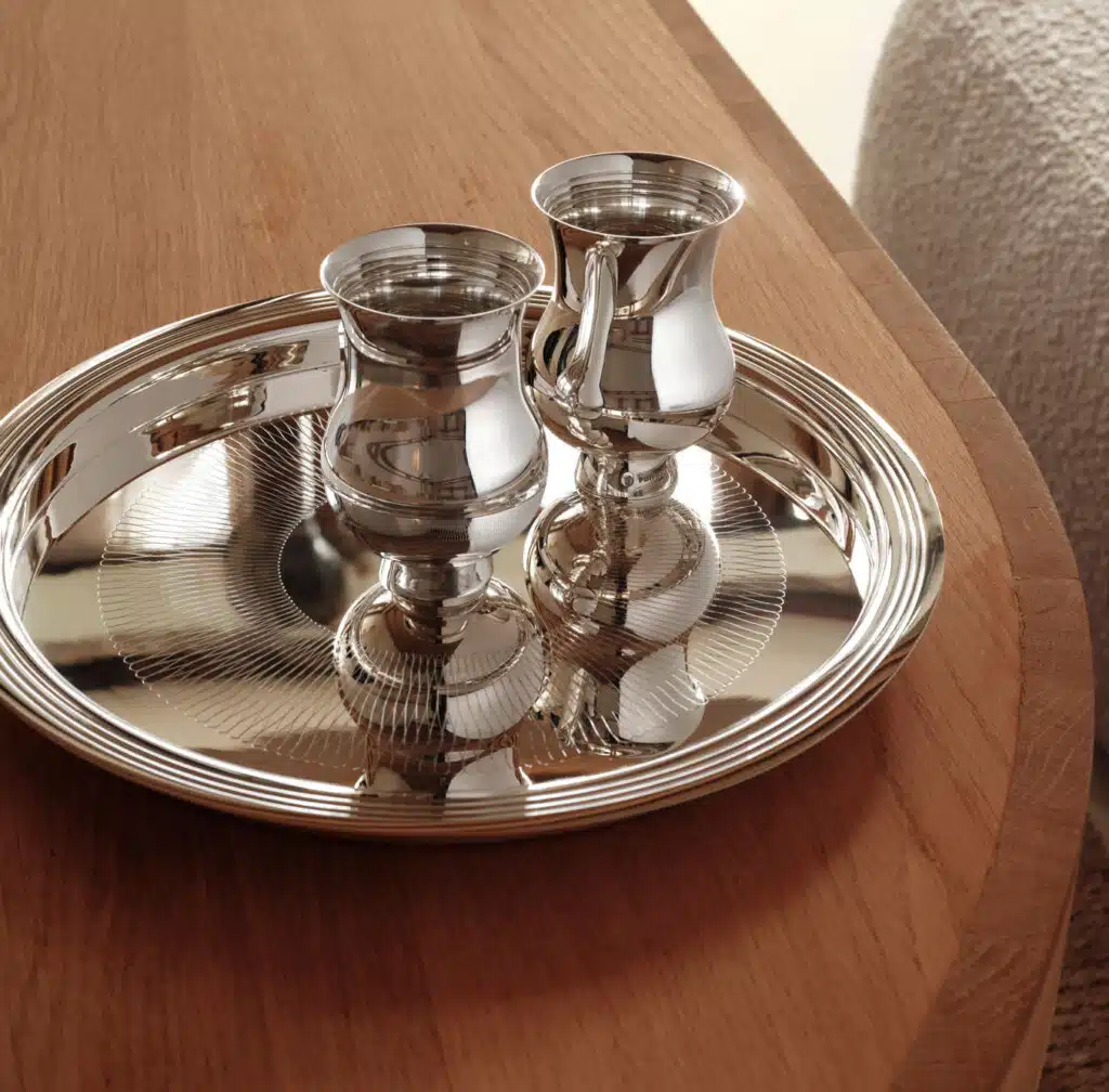 Timbales à champagne en argent massif sur un plateau en argent massif posés sur une table en bois